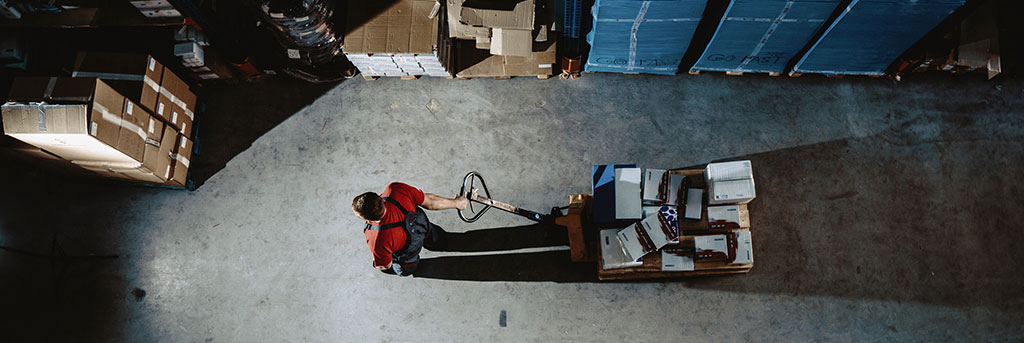 Aerial view of person walking in a warehouse, which be faced with many inventory management challenges