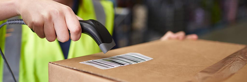 Person using handheld scanner to scan barcode on a box with a barcode system for small business