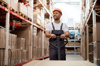 Man in warehouse assessing the best warehousing software with robust features