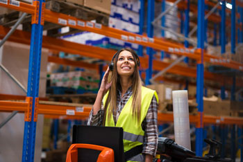 Female in warehouse using the best warehousing software for scaling your business and operations.