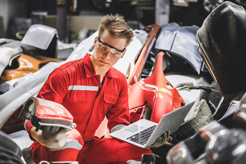 Person with computer using automobile spare parts inventory management software