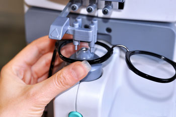 Person working on a pair of glasses managed by  optical frame inventory software.