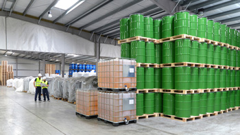 workers in a chemical warehouse manage inventory with ERP for chemical distribution