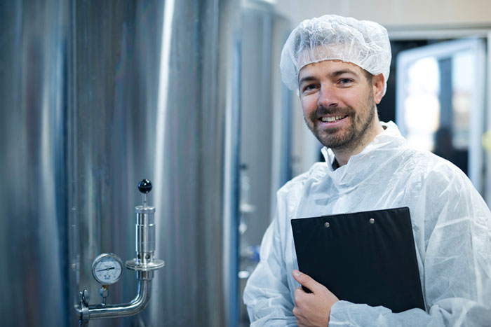 Worker in food processing plant enhancing efficiency and quality with software for food manufacturers
