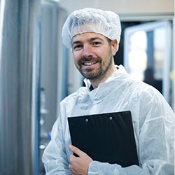 Person in food production facility happy with their food manufacturer software
