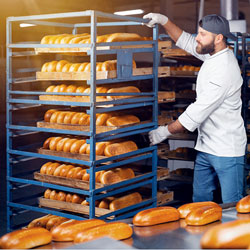 Person in production facility for bread handling operations with a food manufacturing system