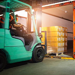 Person on forklift loading truck with boxes to ship orders managed in an inventory control system
