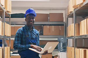 Worker controls inventory and warehouse on laptop with software from our inventory management experts