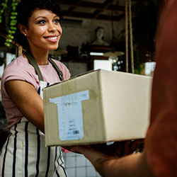 Store owner accepting package shipped with QuickBooks Online inventory management software