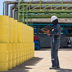 Worker taking stock of barrels at a business using ERP for chemical distribution