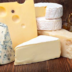 Stacks of different types of cheese being processed and tracked with ERP software for dairy industry