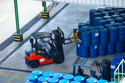 Worker stacks barrels in warehouse using chemical distribution system by Acctivate
