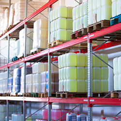 Shelves with containers filled with different liquids are managed by a software for chemical distributors