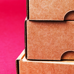 Stacked carton boxes in front of red background produced with corrugated packaging software