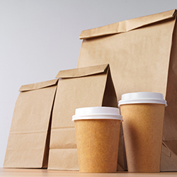 Display of paper bags and to-go paper coffee cups to show production with packaging ERP