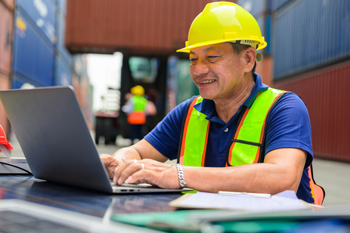 Worker uses laptop to accurately calculate landed cost in response to - What does inventory management software do?