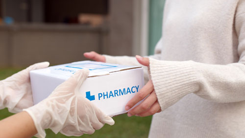 Patient receives medication package box from hospital pharmacy at home with delivery handled with effective inventory management for pharmaceutical distributors