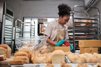 Baker packaging bread for inventory and orders managed in a bakery distribution system