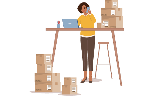 Business person at desk with boxes to ship and computer with inventory software