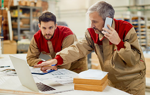 Manage and track various business activities in Acctivate like product returns, sales opportunities, service work, and more. Two people in warehouse handling business activities by following up on a call and utilizing inventory software