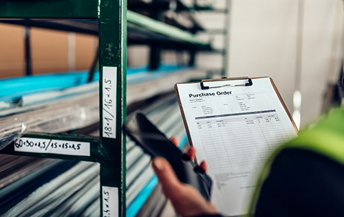 Purchase order management with Acctivate Inventory Software for QuickBooks Person in warehouse holding clipboard with a purchase order