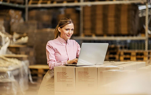 Solve QuickBooks Inventory tracking challenges with Acctivate Inventory Software Person on a laptop in warehouse using QuickBooks Inventory Tracking Software