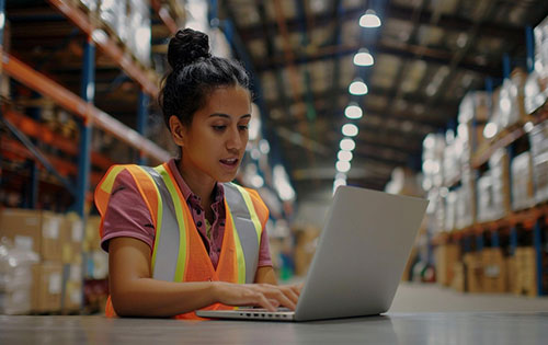 Solve QuickBooks Online Inventory limitations with Acctivate Person on a laptop in warehouse using QuickBooks Online Inventory Software