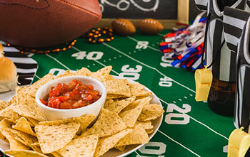 Demand planning and forecasting tools to prepare for seasonal demand like a salsa manufacturer during Super Bowl Salsa on table during Super Bowl party representing seasonal demand for salsa during this period